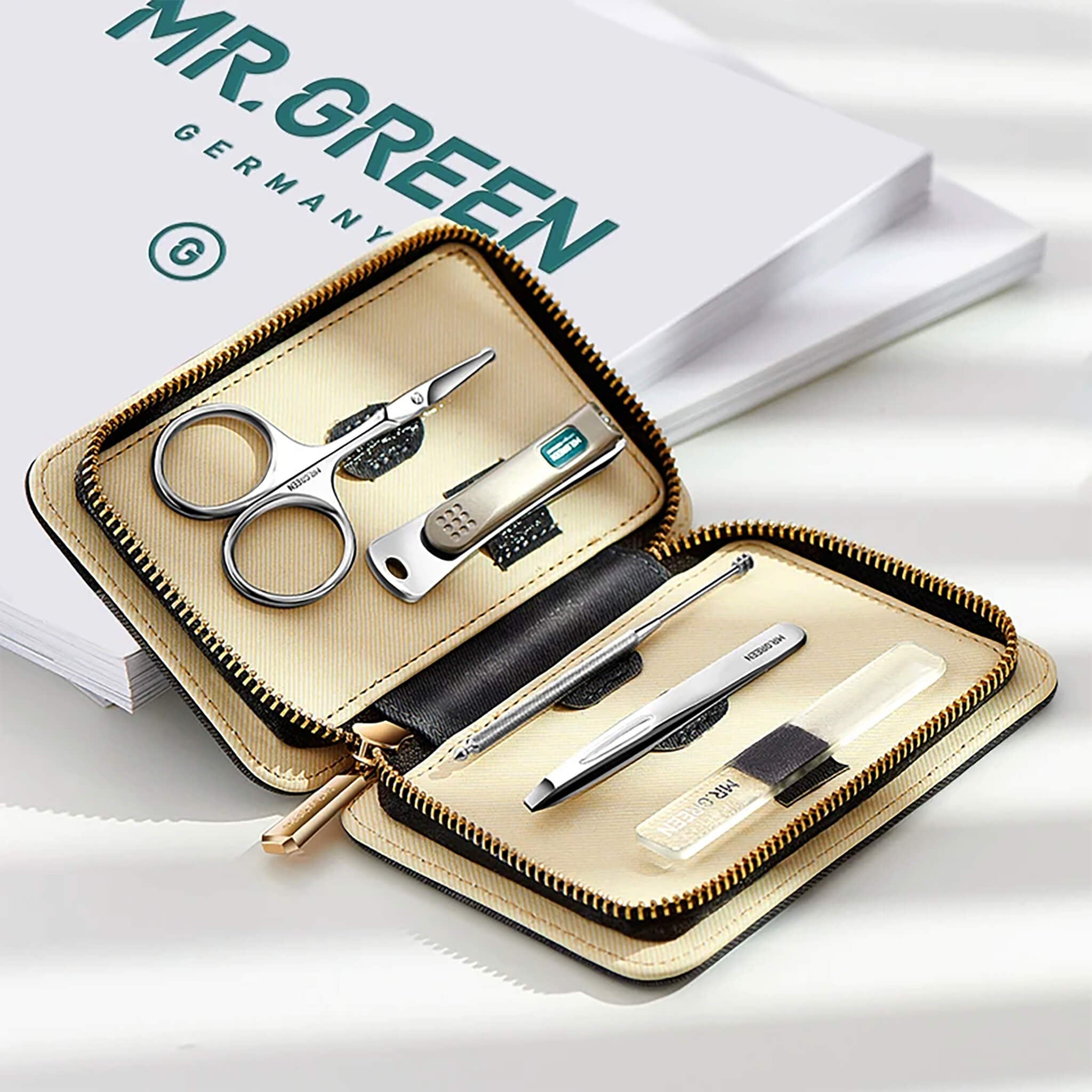 Conjunto MR.GREEN 5 em 1 em estojo bege aberto, com tesoura, corta-unhas, pinça, ferramenta de cutícula e lima de vidro.