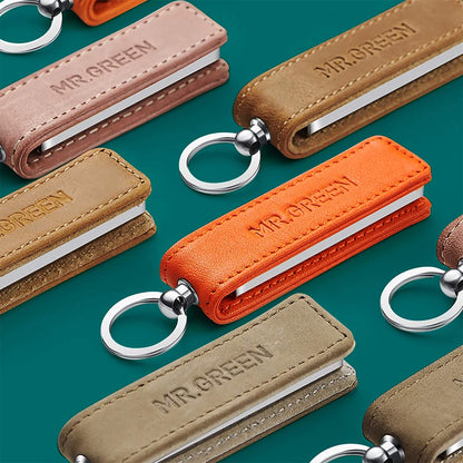 Cortauñas MR.GREEN 3003 ultrafino con funda de cuero naranja; compacto, plegable e ideal para viaje y regalo premium.